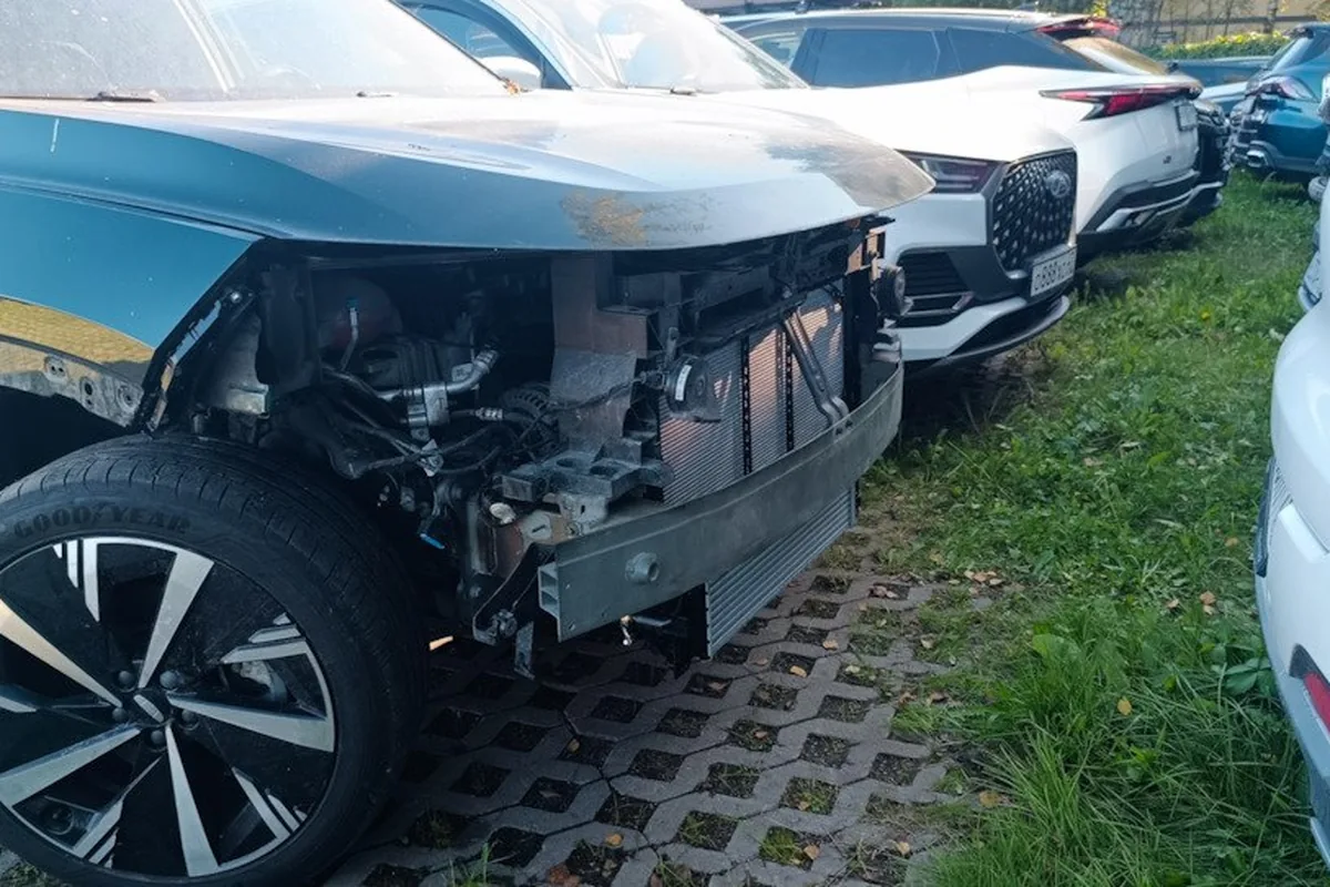 Geely Atlas с разбитой передней частью на площадке кузовного цеха