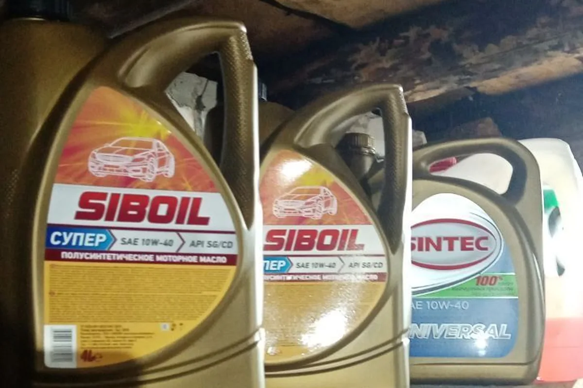 Канистры моторного масла Siboil и Sintec 10W-40 на полке гаража