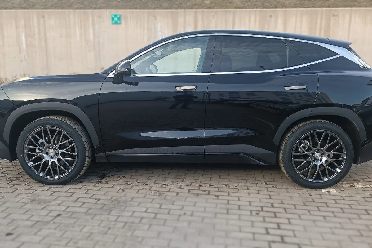 Чёрный Jetour Dashing в профиль у стены