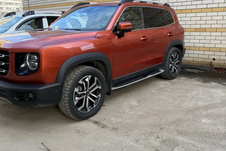 Оранжевый Haval Dargo с боковыми подножками, вид на колесо