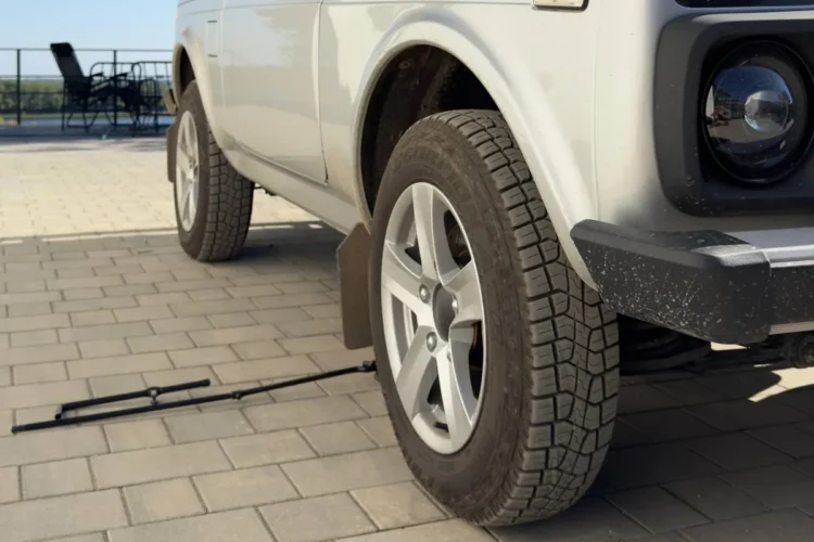 Переднее колесо серебристой Нивы на литье Скад Тайга с шиной 215/65 R16