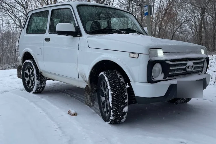 Белая Нива на зимней дороге с шинами 205/65 R16 на литых дисках