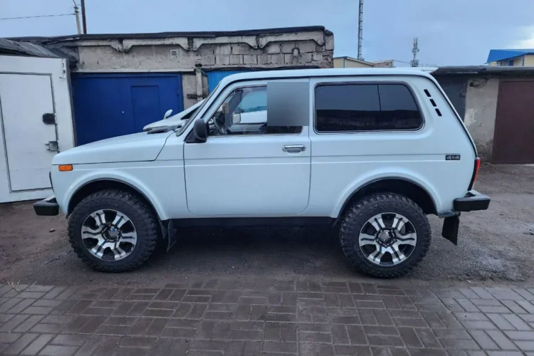 Белая трёхдверка на литых дисках с шинами 205/70 R16, вид сбоку