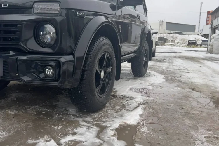 Переднее колесо чёрной Нивы Бронто с шинами 225/75 R16