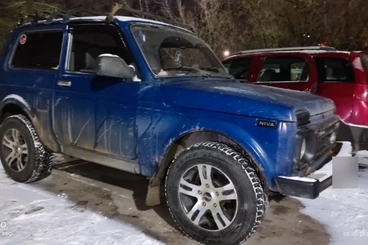 Синяя Нива на литых дисках с шипованными шинами 215/70 R16 на снегу