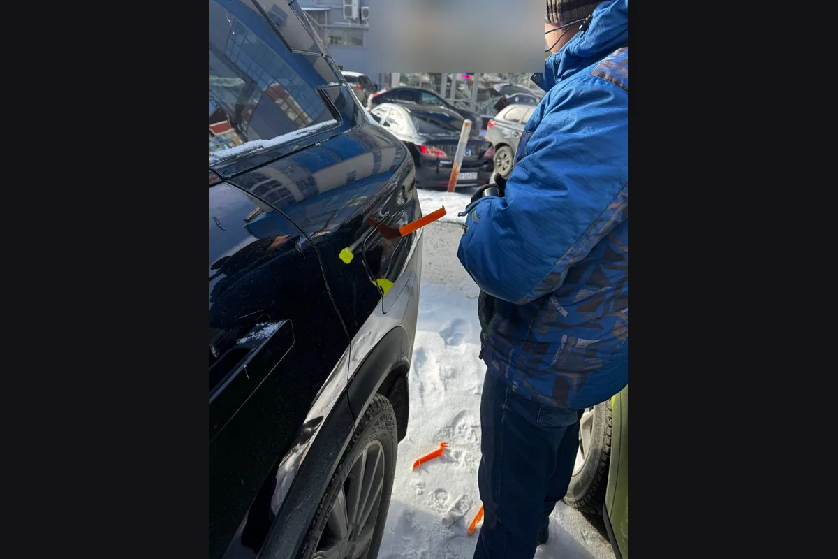 Владелец открывает примёрзшую крышку бензобака Jaecoo J7 на заправке зимой