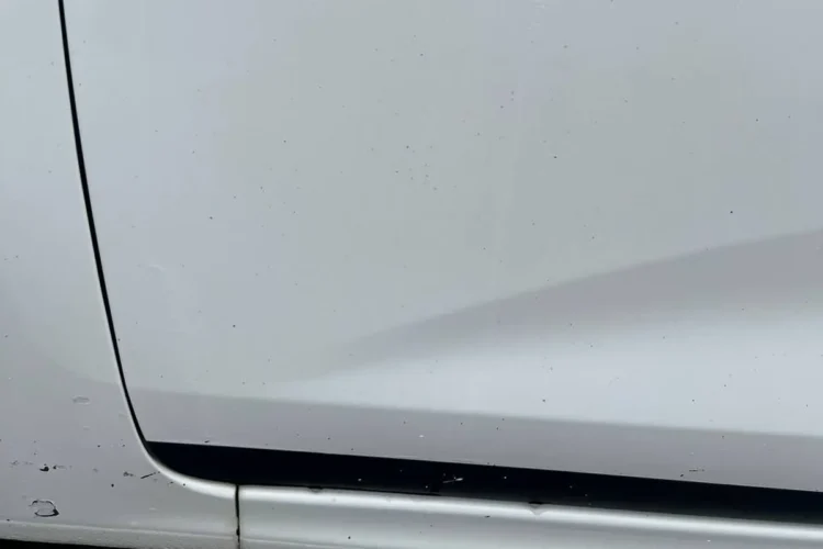 Мелкие рыжие точки на белой двери Kia Rio