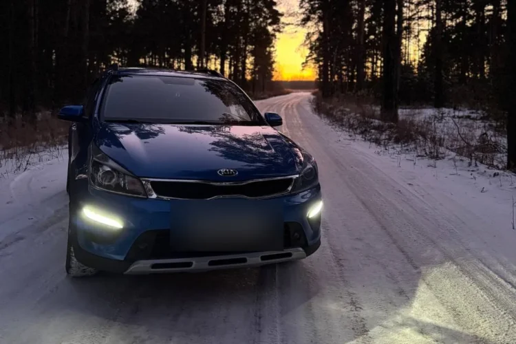 Синий Kia Rio X-Line с включёнными ходовыми огнями
