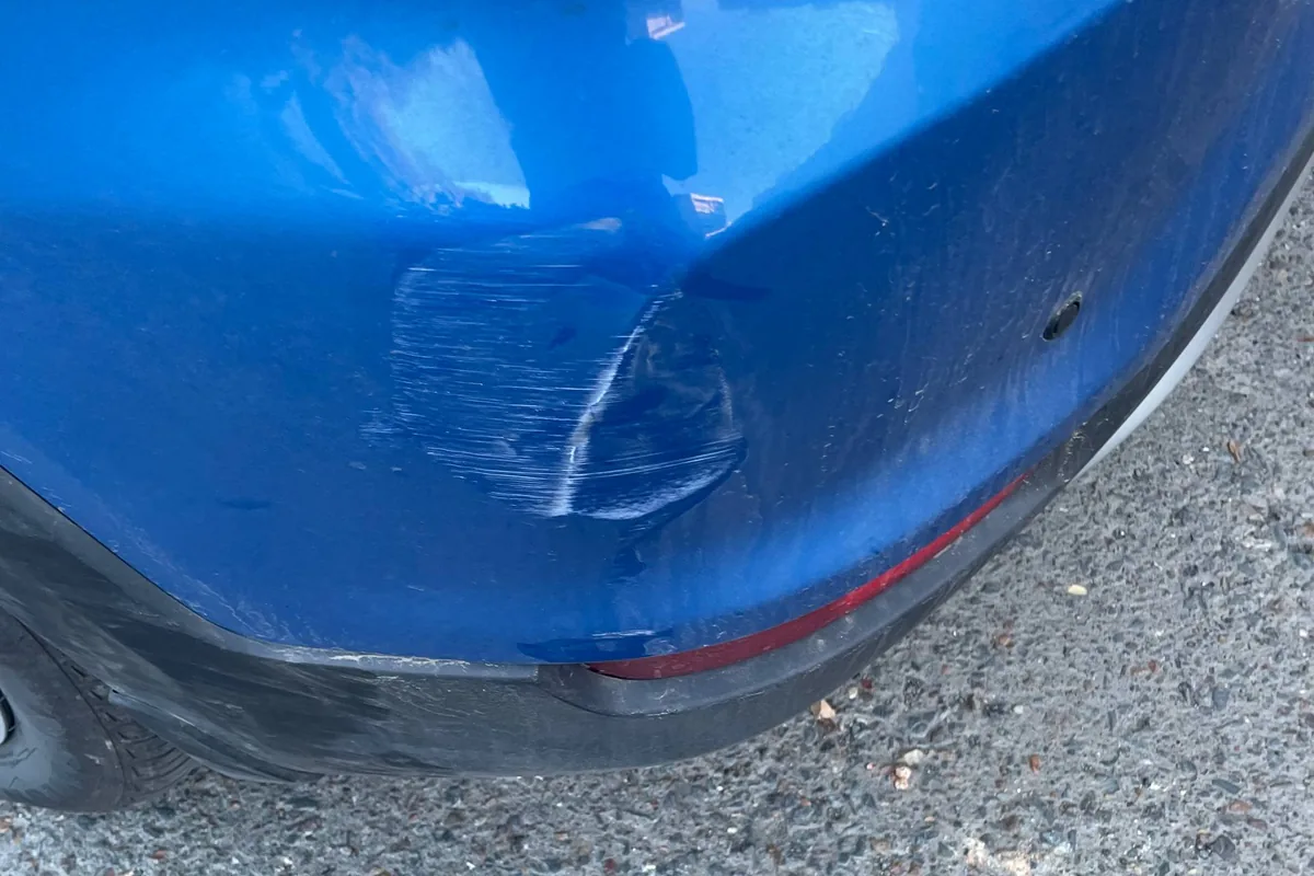Царапины и вмятина на заднем бампере синего Kia Rio