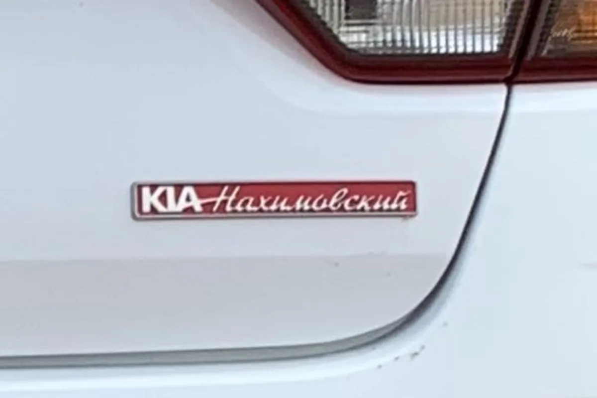 Шильдик дилера на крышке багажника Kia Rio 4