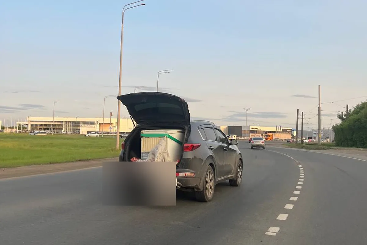 Kia Sportage 4 везёт холодильник в открытом багажнике