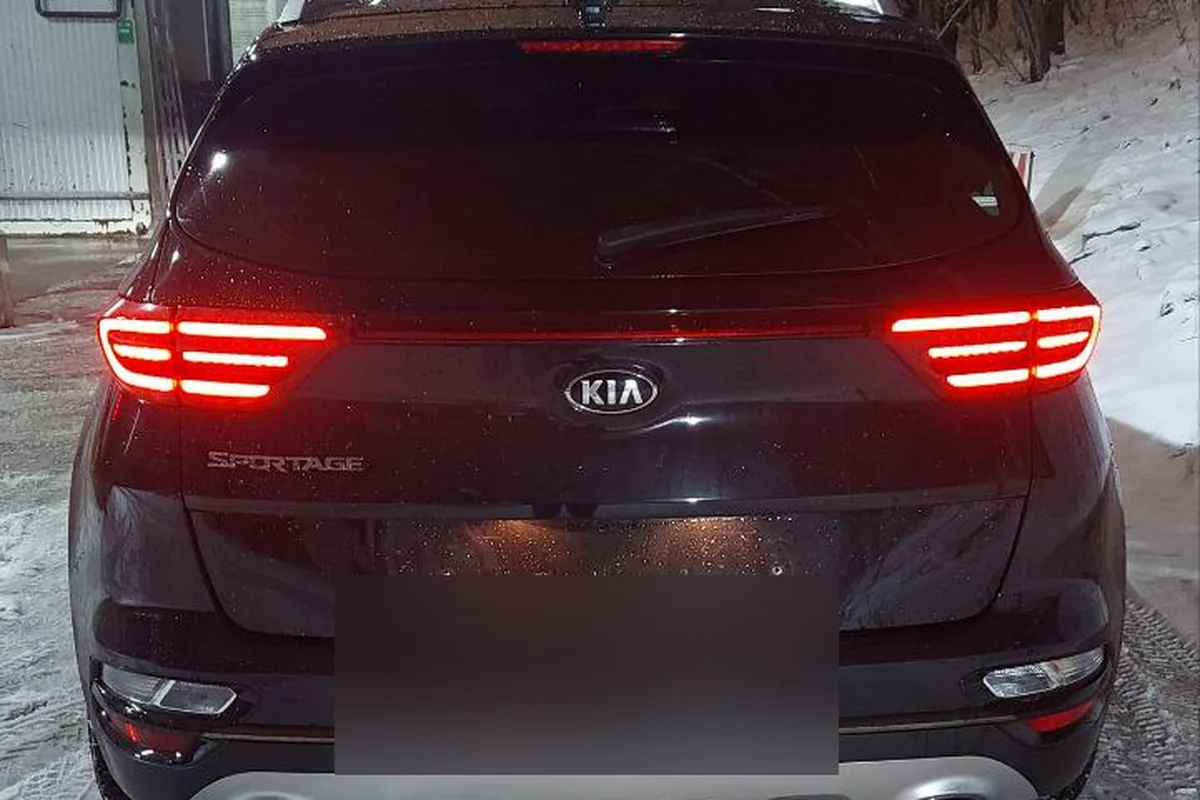 Чёрный Kia Sportage 4 сзади с включёнными фонарями