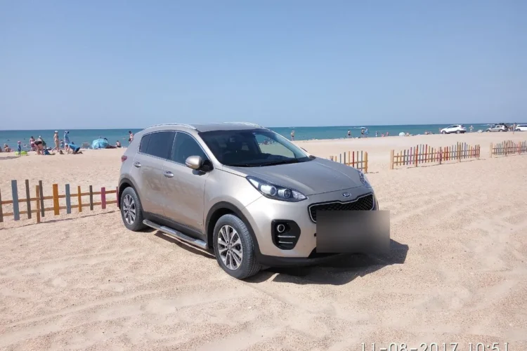 Бежевый Kia Sportage 4 с подножками на песчаном пляже