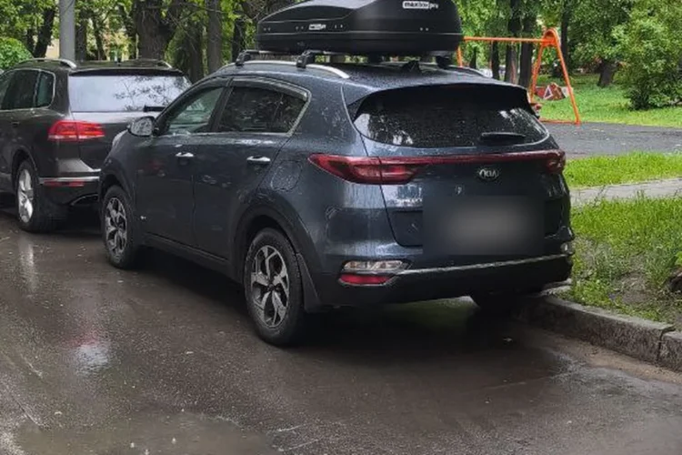 Kia Sportage 4 с боксом на крыше на стоянке