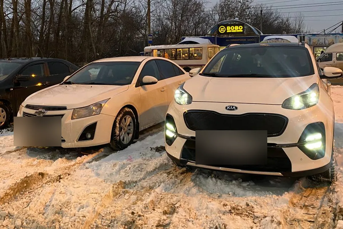 Белый рестайлинговый Kia Sportage 4 рядом с седаном Chevrolet Cruze