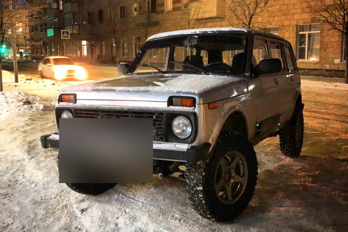 Серебристая трёхдверная Нива на зимней улице вечером
