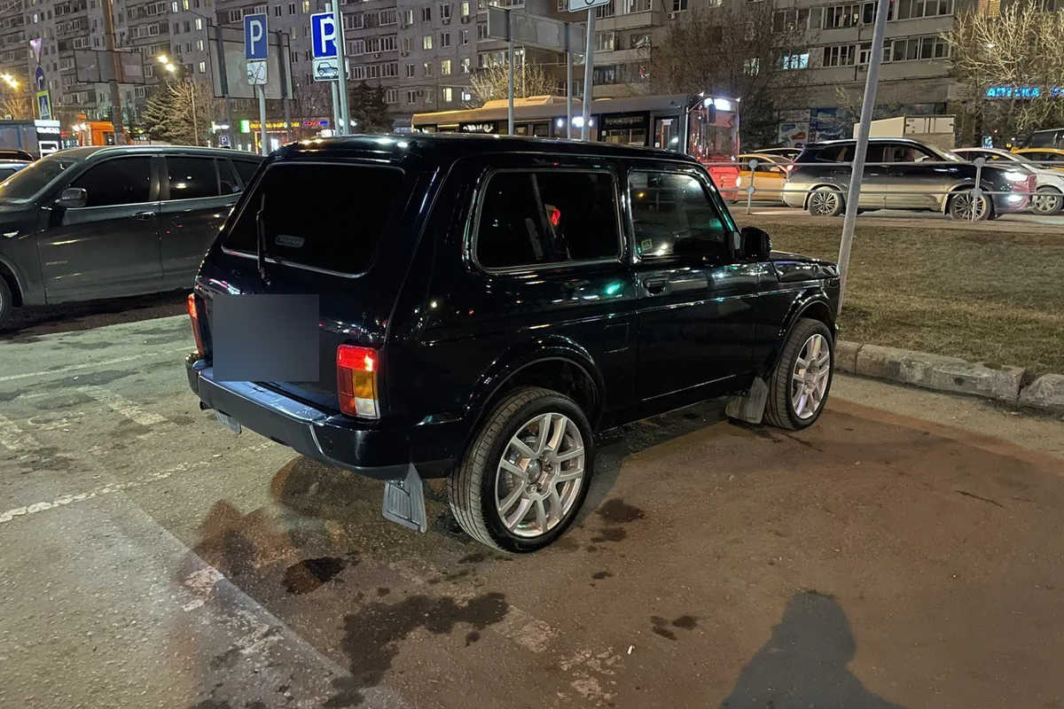 Чёрная Нива на низкопрофильной резине и 18-дюймовых литых дисках на парковке