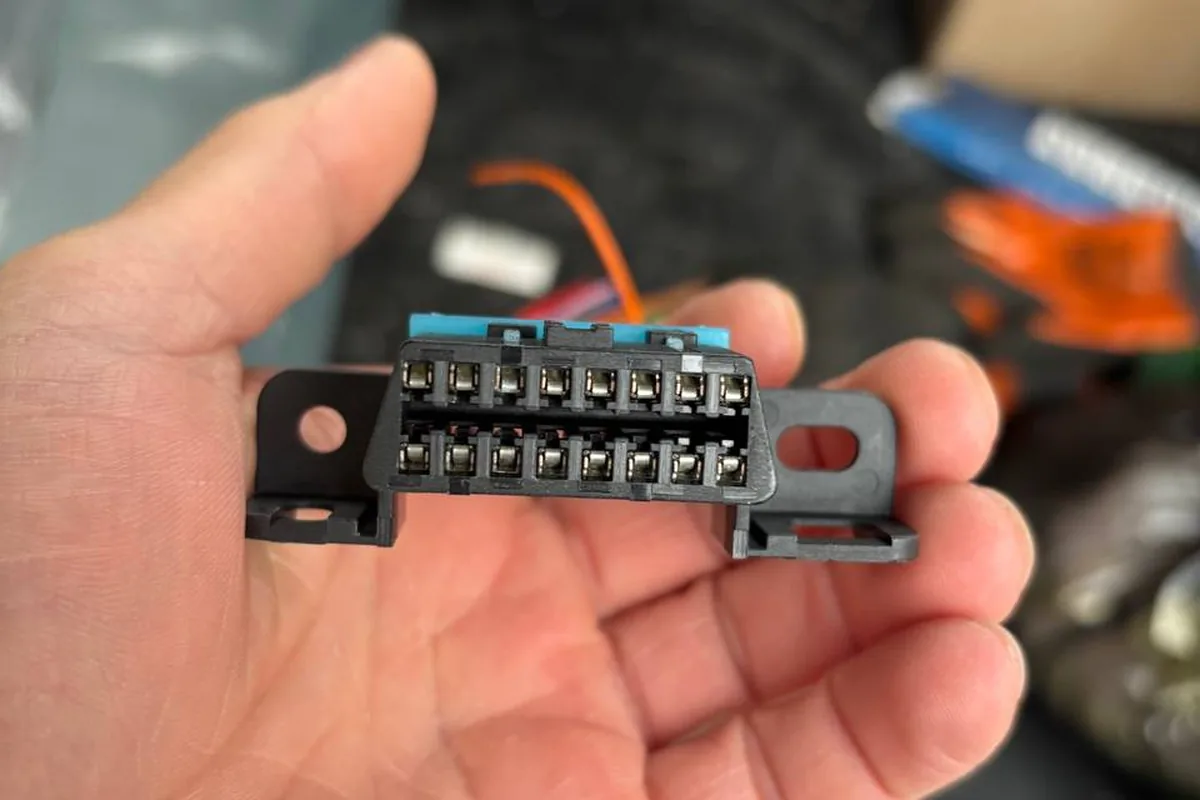 16-контактная колодка диагностики OBD-II в руке