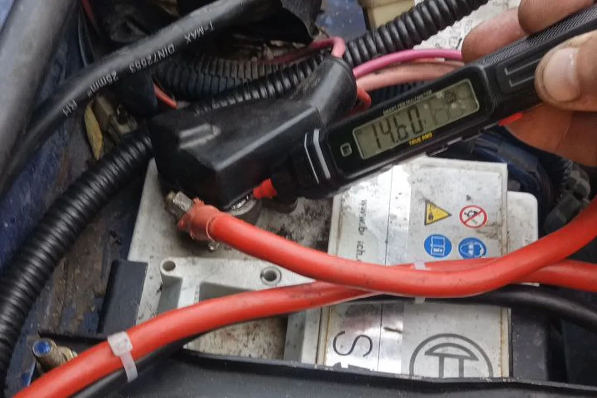 Мультиметр показывает 14,60 В на клеммах аккумулятора Bosch под капотом синей Нивы, рядом новые толстые провода