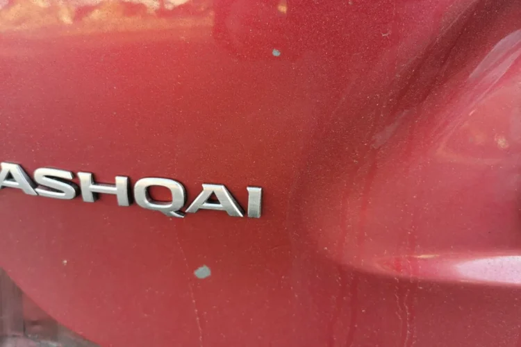 Точечные вздутия краски на заднем крыле красного Nissan Qashqai J11
