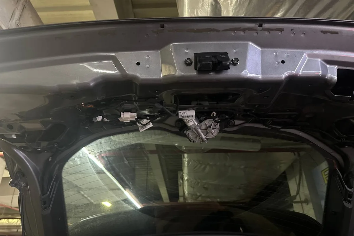 Снятая обшивка двери багажника Nissan Qashqai для замены ламп подсветки номера