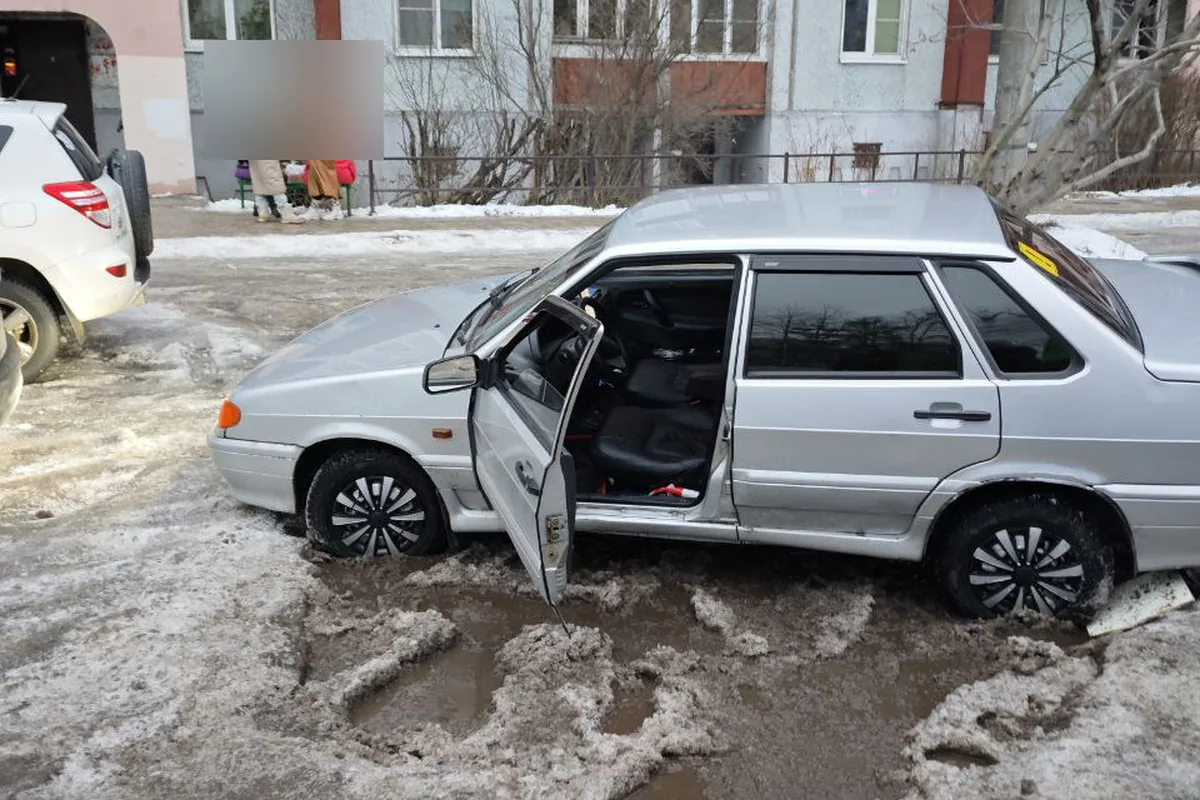 Застрявший в снежной каше седан ВАЗ во дворе