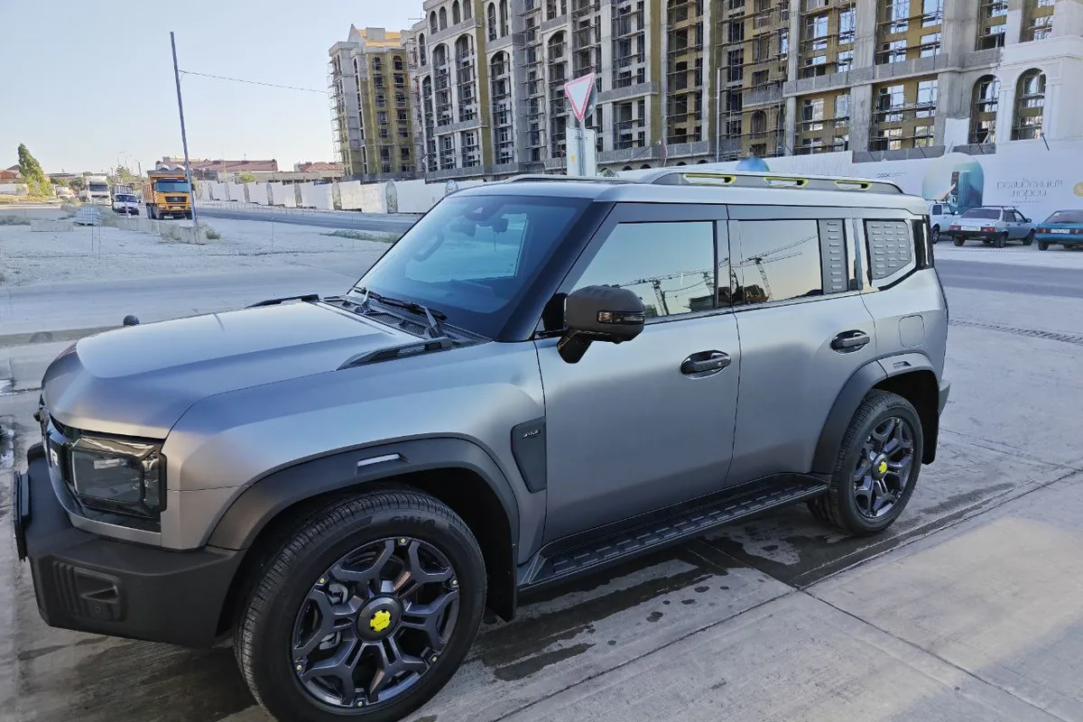 Jetour T2 серого цвета, вид сбоку на городской улице
