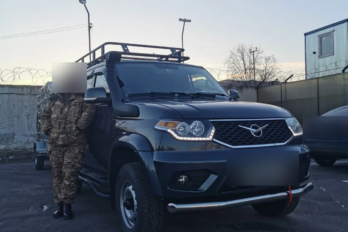 Чёрный УАЗ Патриот с трубой защиты бампера и экспедиционным багажником
