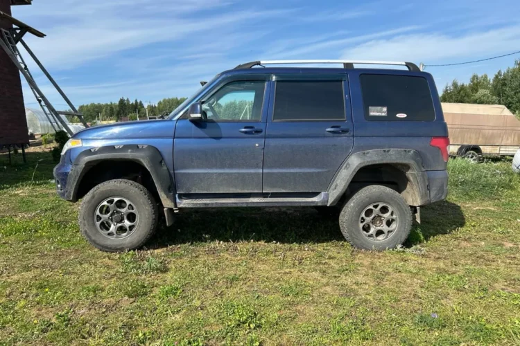 Синий УАЗ Патриот в профиль на 32-дюймовых колёсах