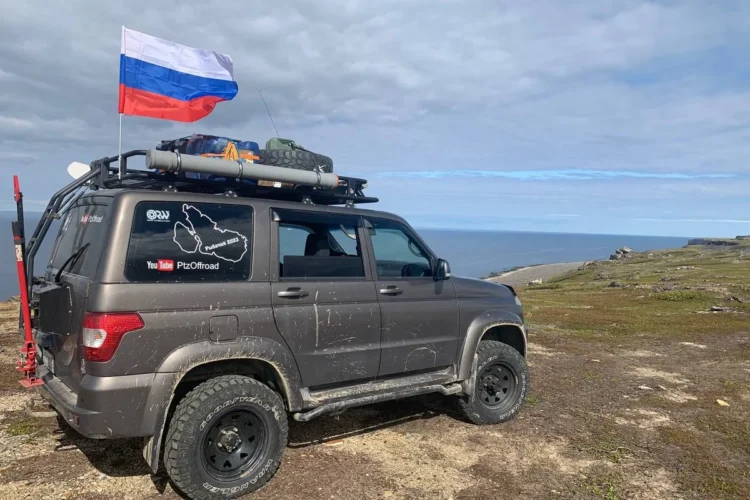 УАЗ Патриот с экспедиционным багажником и запаской на крыше у моря