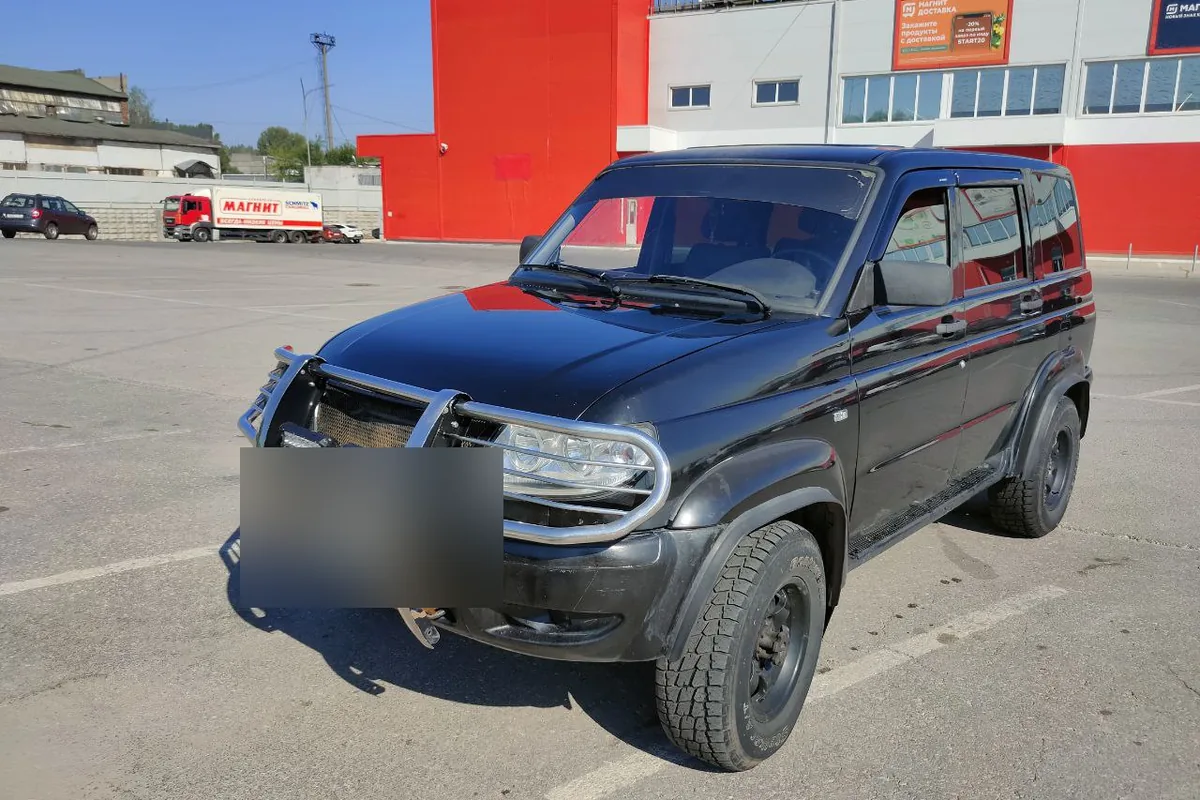 Чёрный УАЗ Патриот с кенгурятником JAOS на парковке