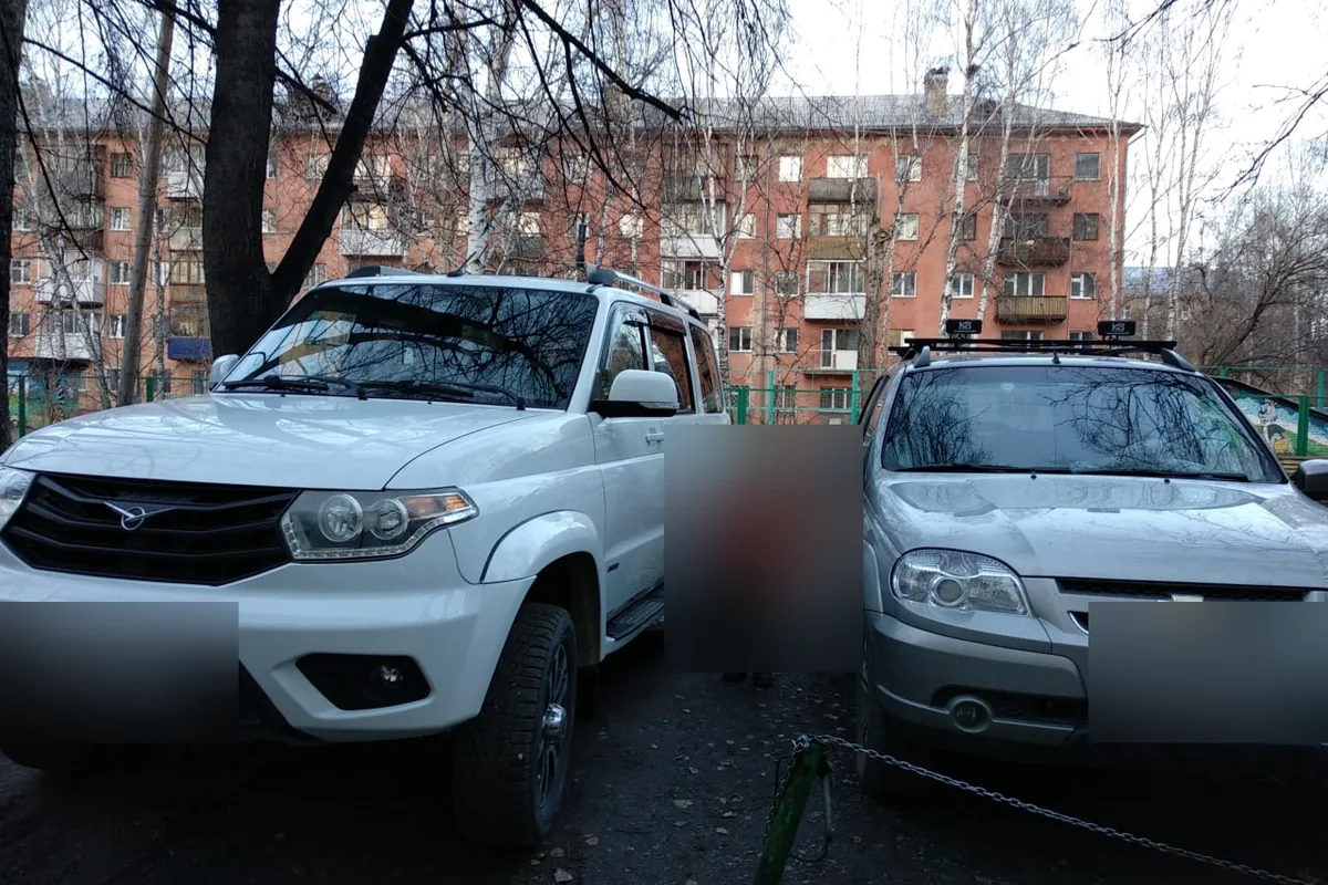Белый УАЗ Патриот рядом с Шевроле Нивой во дворе