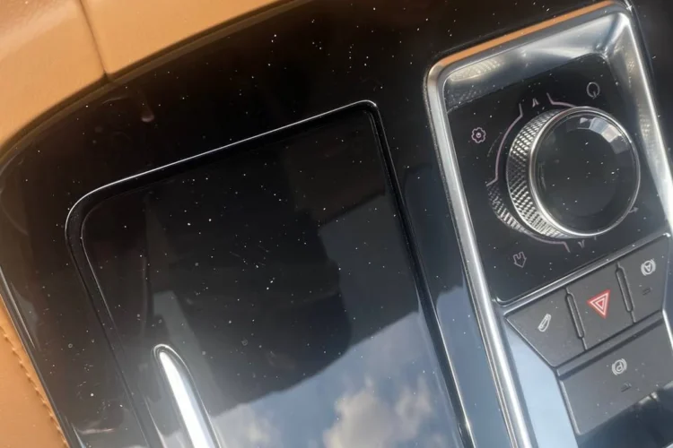 Глянцевая чёрная накладка центрального тоннеля Jetour X70 Plus с видимой пылью