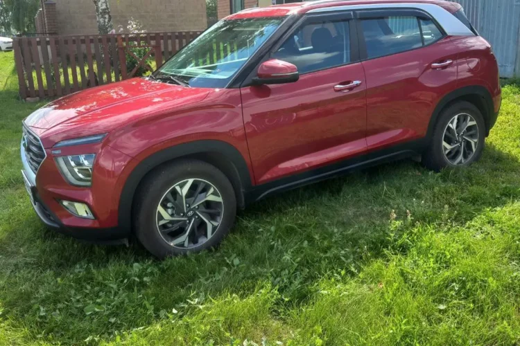 Красная Hyundai Creta 2 на траве у дома