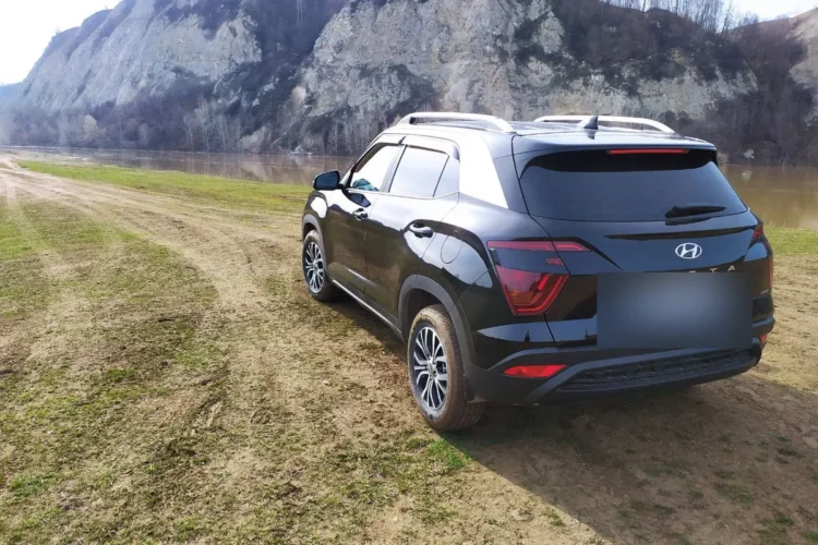 Чёрная Hyundai Creta 2 сзади на грунтовке у реки