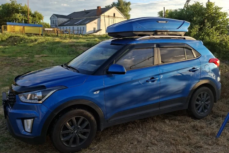 Синяя Hyundai Creta с боксом на крыше на летних колёсах