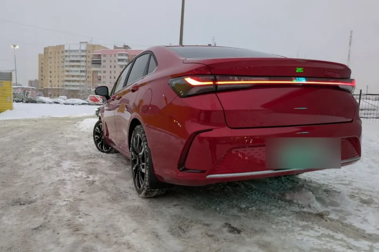 Задняя часть красного седана со светящейся светодиодной полосой
