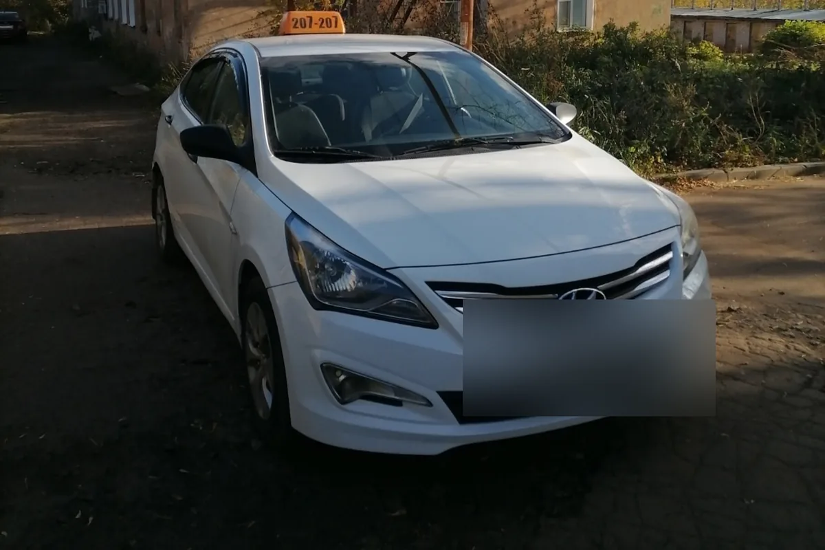 Белый Hyundai Solaris 1 рестайлинг с шашкой такси