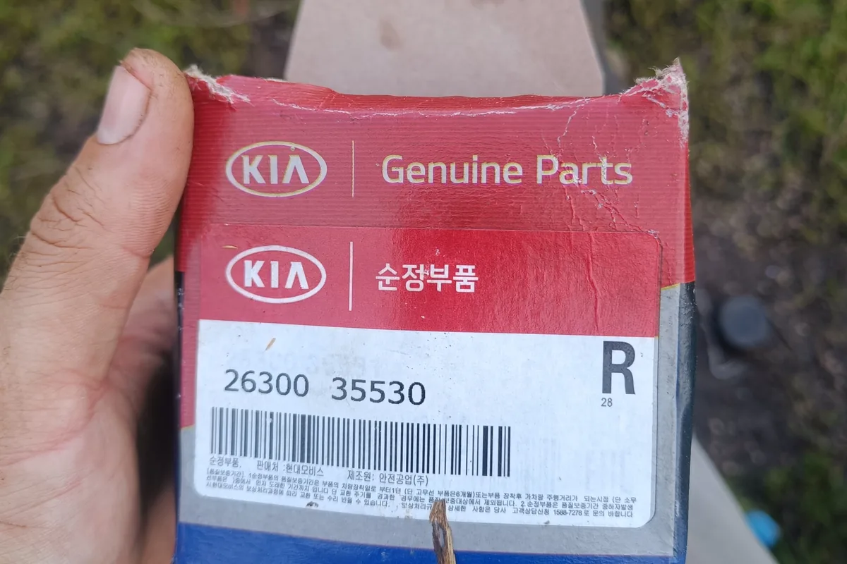 Коробка оригинального масляного фильтра Kia Genuine Parts в руке