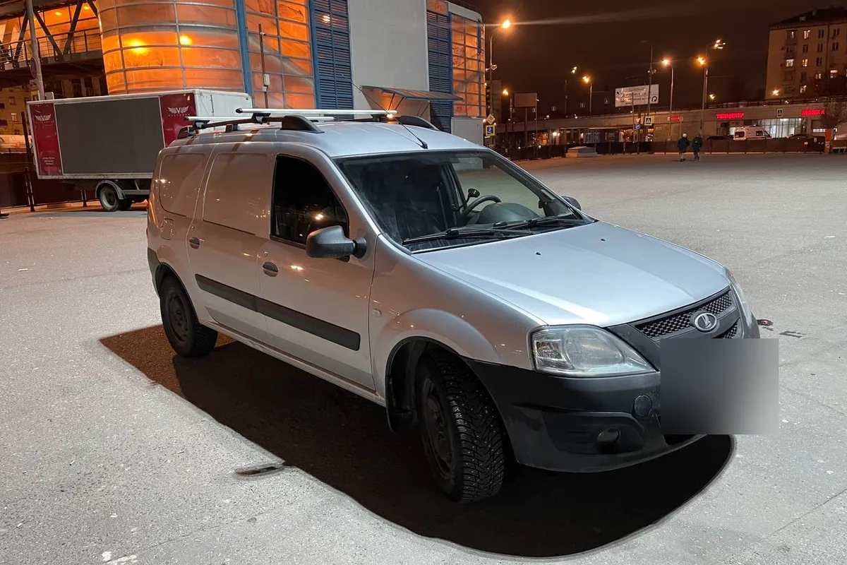 Серебристый фургон Lada Largus с поперечинами на крыше
