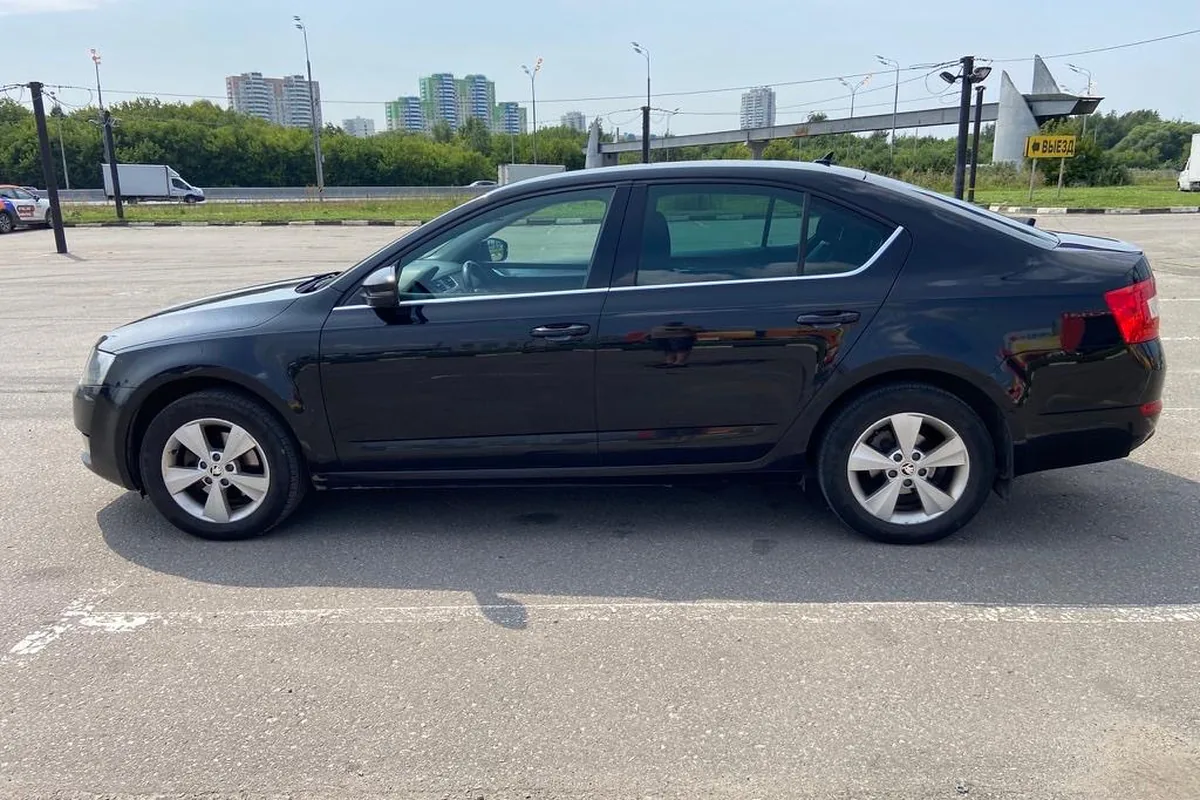 Чёрная Skoda Octavia A7 2.0 TDI сбоку на парковке