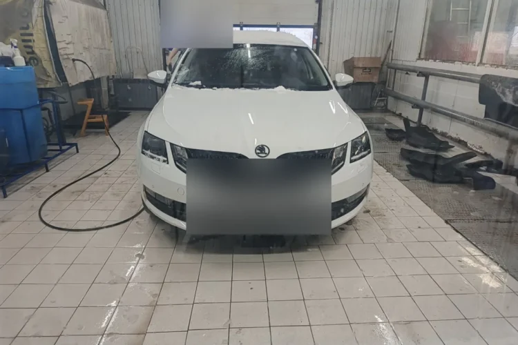 Белая Skoda Octavia A7 после рестайлинга в боксе мойки