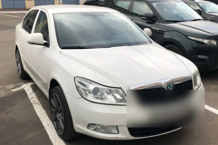 Белая Skoda Octavia A5 после рестайлинга на парковке