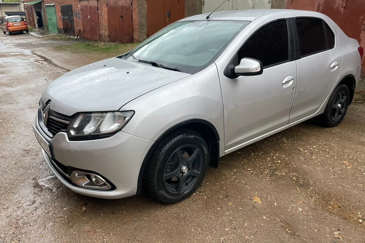 Серебристый Renault Logan 2 2015 года с роботом