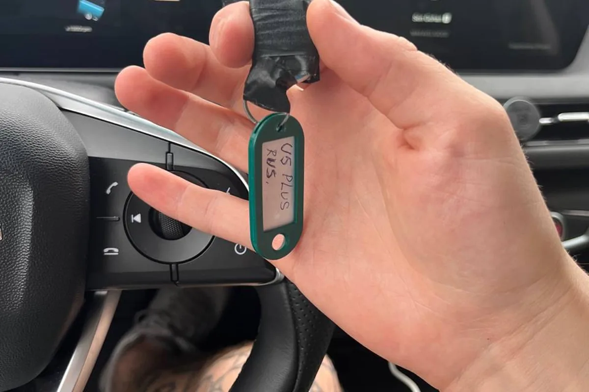 Рука водителя держит USB-флешку с биркой U5 PLUS