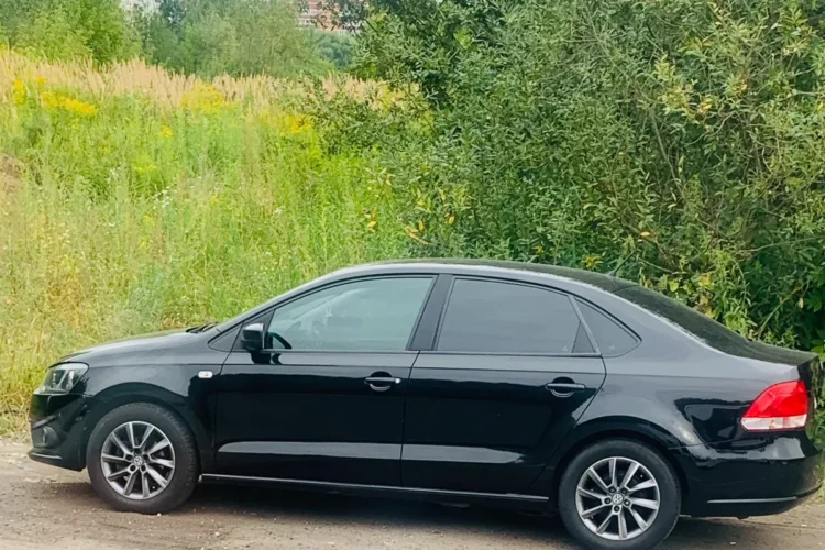 Чёрный Volkswagen Polo седан на литье R15 сбоку