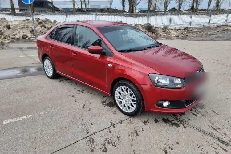 Красный Volkswagen Polo седан на литых дисках R16