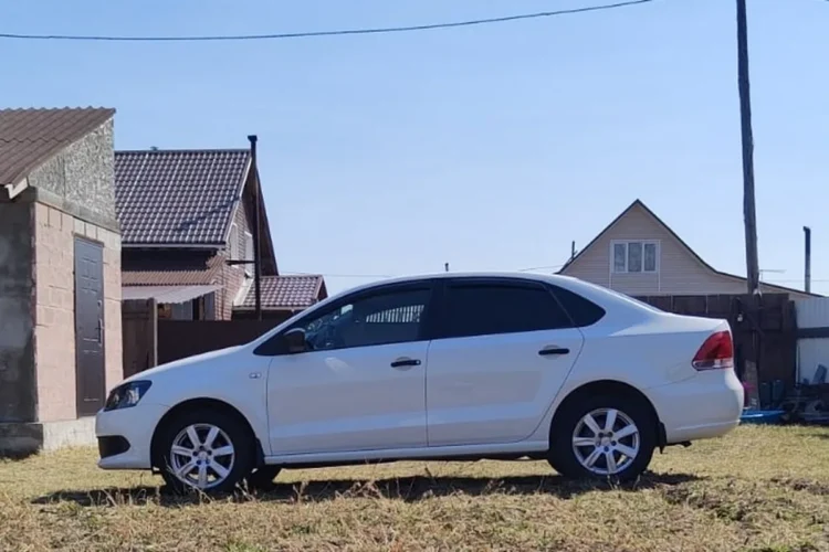 Белый Volkswagen Polo седан на литых дисках R16 сбоку