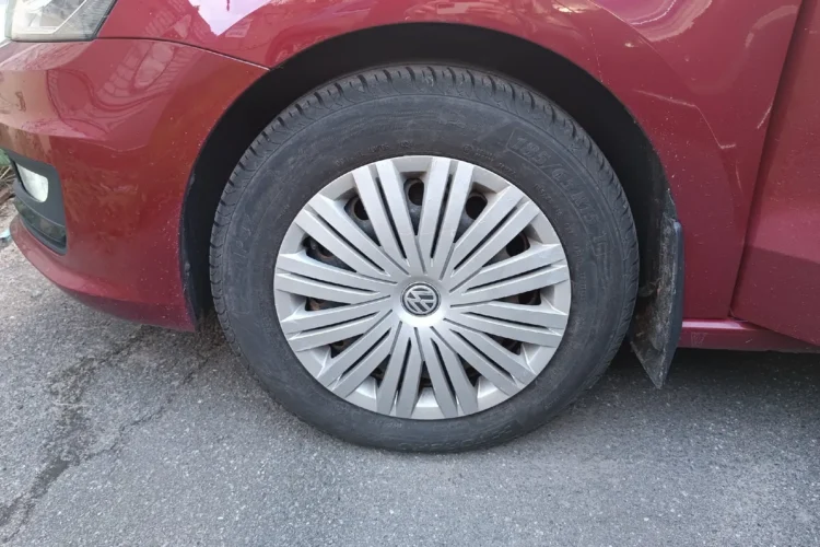 Переднее колесо 185/65 R15 с колпаком на красном Volkswagen Polo седан