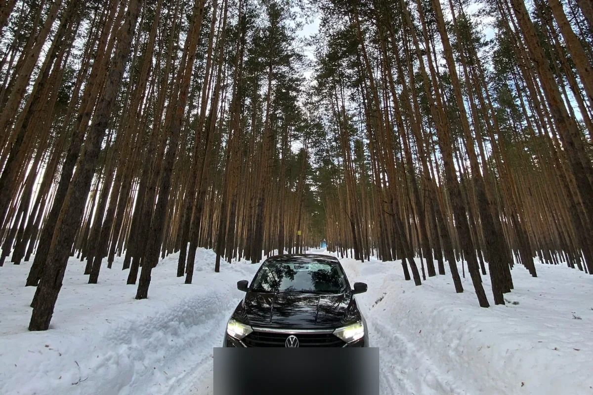 Чёрный Volkswagen Polo лифтбек на зимней лесной дороге
